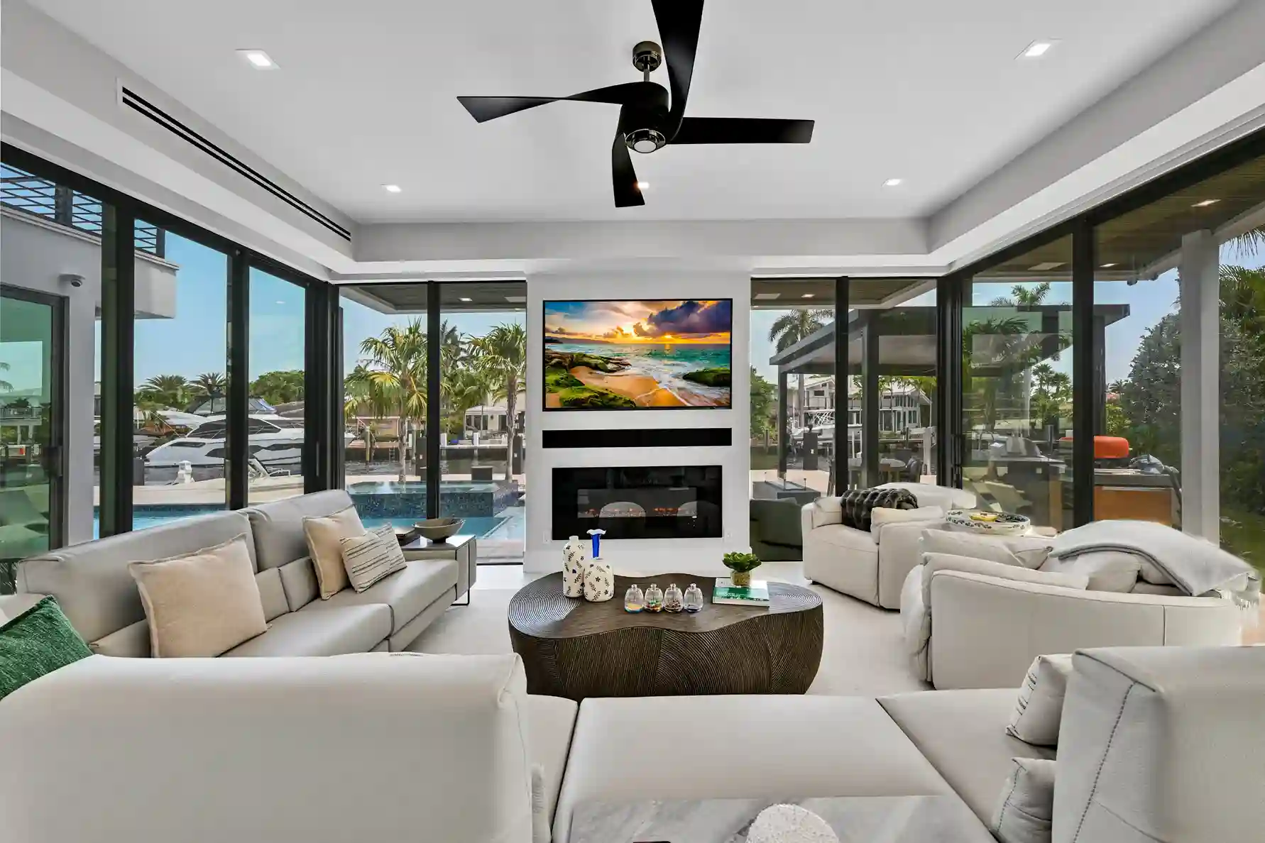Contemporary living room with floor-to-ceiling windows, waterfront views, and modern fireplace.