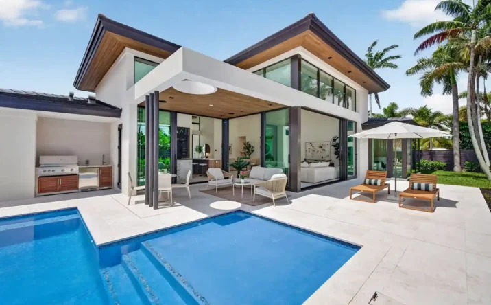 Modern luxury home exterior featuring covered patio, outdoor seating, and contemporary architecture.