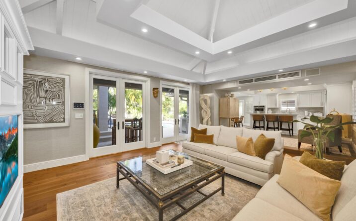 Open-concept living room with coffered ceiling by CKA Construction