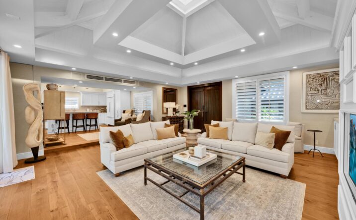 Open-concept living room with coffered ceiling by CKA Construction