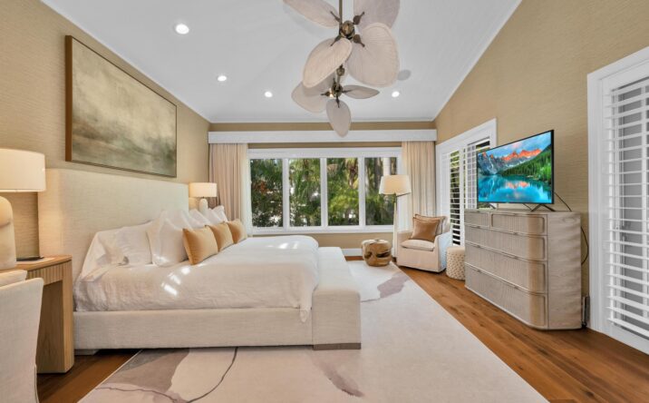 Bright bedroom with ceiling fan and outdoor access by CKA Construction