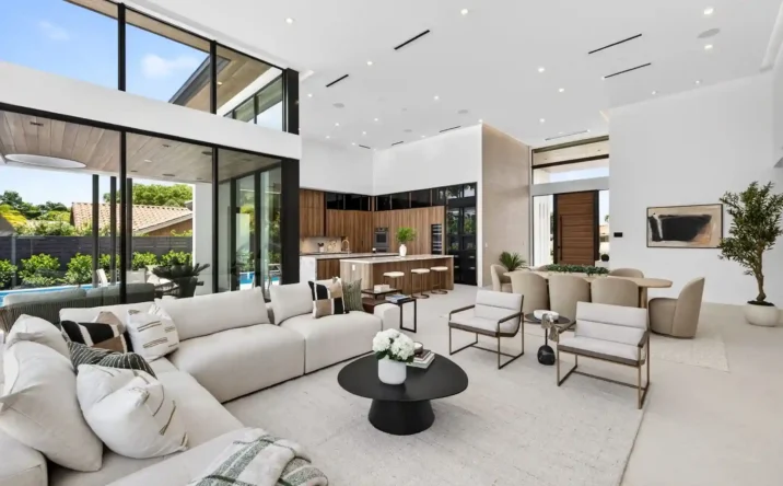 Open-concept luxury living and dining area with vaulted ceilings and expansive glass walls.