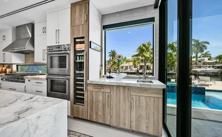 Luxury modern kitchen with built-in appliances, custom cabinetry, and large picture window.