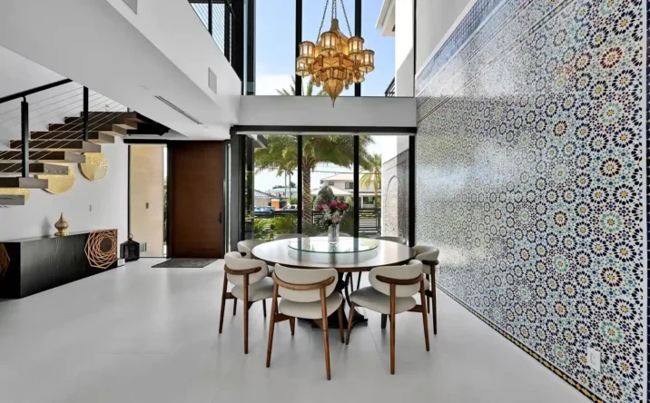 Modern luxury foyer with soaring ceilings, designer chandelier, and glass front entry.