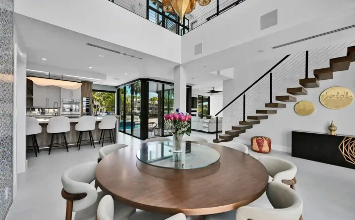 Open-concept luxury living space with floating staircase, double-height ceilings, and modern design.