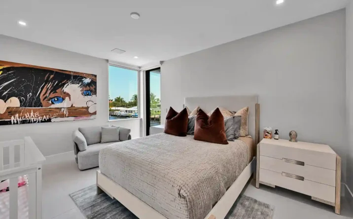 Contemporary bedroom with expansive windows, minimalist furnishings, and natural light.