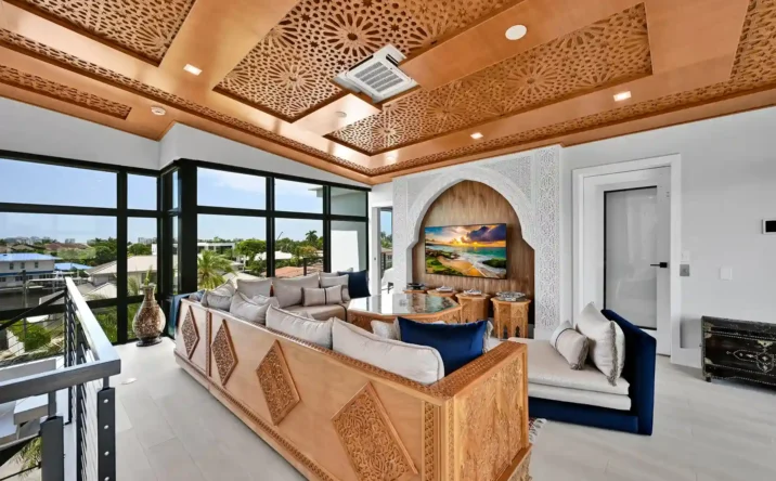 Luxury outdoor entertaining area featuring a wood ceiling, built-in summer kitchen, and waterfront views.