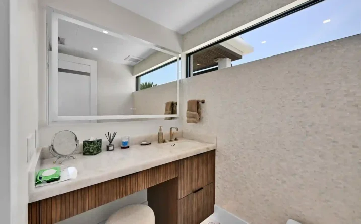 Modern luxury bathroom with floating vanity, frameless mirror, and contemporary finishes.