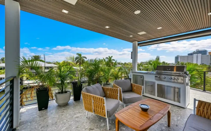 Luxury covered patio featuring wood ceiling, recessed lighting, and modern outdoor seating area.