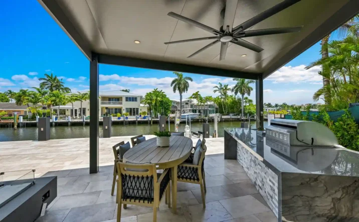 Covered outdoor patio with wood ceiling, ceiling fan, and panoramic waterfront views.