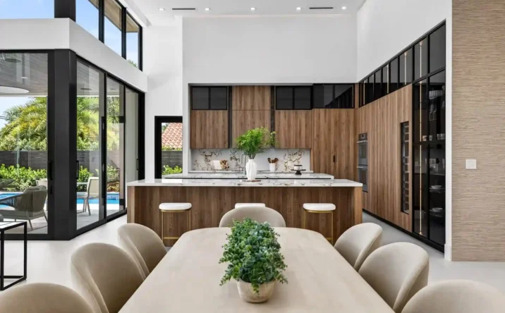 Modern luxury kitchen featuring a large island, wood cabinetry, and bright open-concept design.